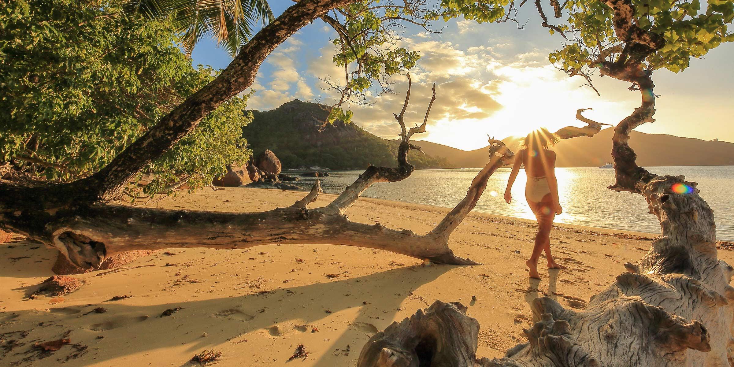 Woman walking at the beach in the Seychelles